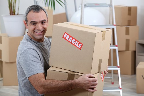 Furniture pick-up team collecting a sofa from an Acton flat